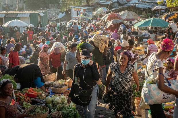 Personas recorren una feria para comprar comida durante la tarde de fin de año, en Puerto Príncipe, Haití.
