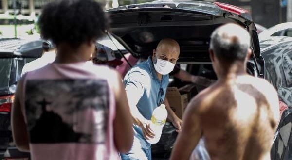 Voluntarios entregan alimentos y productos de limpieza en Río de Janeiro, Brasil, por la crisis del coronavirus.