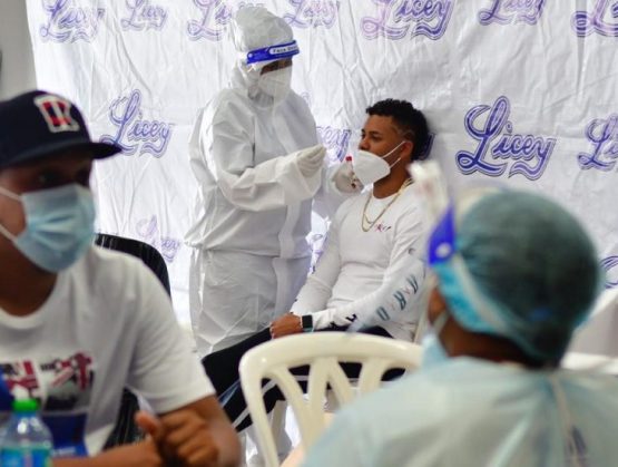 El acto sanitario se llevó a cabo con miras de iniciar este lunes los entrenamientos con vista a la temporada del béisbol invernal 2020-2021, pautado para arrancar el 15 de noviembre.

Cónsono con lo dicho por la doctor Mora, el también médico y presidente del Licey, doctor Domingo Pichardo Peña, definió la jornada de “totalmente exitosa” e informó que los jugadores que no pudieron asistir a tomarse la prueba este domingo, están citados para este lunes a las 10:00 de la mañana en el mismo Estadio Quisqueya Juan Marichal, para cumplir con el protocolo establecido entre la Liga de Béisbol Profesional de la República Dominicana (Lidom) y el Ministerio de Salud.

El doctor Pichardo, lo mismo que la doctora Mora, recordaron que quienes no se hicieron el domingo o se hagan este lunes la prueba, no podrán incorporarse a los entrenamientos, hasta el próximo lunes 26 del corriente mes, cuando será la próxima tanda para el equipo azul, con vista al torneo dedicado, In Memorial, al expresidente de los Tigres, don José Manuel Fernández.

“El proceso ha fluido de manera diáfana, rápida, organizada; ha habido una asistencia masiva de todos los jugadores, el personal de club house, la directiva, el personal de comunicaciones y Operaciones de béisbol; considero que ha sido una jornada totalmente exitosa”, expuso el doctor Pichardo.

A la toma de pruebas asistió cerca de un centenar del personal convocado, incluidos 40 jugadores, cuerpo técnico o coaches y los directivos, entre ellos el doctor Pichardo, el expresidente y actual tesorero del Club Atlético Licey, licenciado Miguel Ángel Fernández y el administrador Parmenio Rodríguez. De acuerdo a la doctora Mora, un 80 por ciento de los asistentes prefirió la prueba con hisopo y el resto de saliva.

Los entrenamientos del Licey comenzarán este lunes en Baseball City, Boca Chica, a partir de las 2:30 de la tarde, luego de que se tengan los resultados de las pruebas, las que se tardan unas 24 horas. La partida de jugadores y personal desde las oficinas en el Quisqueya, será a la 1:00 de la tarde.

Representante de Sanidad

La doctora Mora recordó que su coordinación en la toma de pruebas es en representación del ministro de Salud, doctor Plutarco Arias y el viceministro de Planificación y Desarrollo de la misma cartera, doctor Edward Guzmán, quien está llevando la responsabilidad a nivel nacional del protocolo de salud por la pandemia de coronavirus.

Indicó que antes de llegar al Quisqueya y al operativo, hubo una buena coordinación y comunicación fluida, no solo con directivos, sino también con el staff médico del equipo, que encabeza el doctor David Abreu; y que el ministro de Salud ha orientado en dar todo el apoyo, no solo al Licey, sino a todos los equipos.

“Pero en esta ocasión (el doctor Plutarco Arias) nos ha orientado a brindarles las indicaciones sobre las muestras, también sobre los síntomas, las conductas y las acciones a asumir con la responsabilidad social que tenemos, para evitar cualquier contagio en el equipo”, expresó la doctora Mora, cuyo personal conformado por otros médicos del Ministerio de Salud, estuvieron muy bien protegidos y llevando el proceso con rigurosidad.

“No solamente estamos acá en calidad de hacer pruebas para identificar o detectar, sino también orientando, haciendo una breve historia clínica de todo el personal del equipo para poder identificar si hay algún factor de riesgo y orientar sobre un posible contagio de covid-19”, acotó la coordinadora de proceso de pruebas PCR.

Resaltó que en el proceso de las tomas de prueba, el personal del Licey estuvo muy bien organizado, con muchos colaboradores, “hemos encontrado la distribución de los espacios, de los horarios, el comportamiento del equipo ha sido muy buen visto por parte nuestra, de Salud Pública, entonces entendemos que lo que comienza bien, tiene que terminar bien”.

Recordó que el compromiso por parte del ministro Plutarco Arias, ha sido en hacer énfasis, en que la condición ‘sine qua non’ y de la Liga de Béisbol, como ente gerente del proceso de pruebas PCR a los equipos es que, para que los jugadores entrar a las prácticas, es tener las pruebas de coronavirus realizadas.

Representante de Lidom

El licenciado Valentín Contreras, coordinador por la Lidom con Salud Pública para este operativo, resaltó la dedicación y profesionalidad del personal del Ministerio en la realización, tomando en cuenta, además, que lo hacen un día como el domingo.

Contreras señaló, que junto al personal del Licey, también se realizó la toma de pruebas a los árbitros que intervendrán en el torneo, ya que a partir de esta semana comenzarán los partidos de exhibición o pretemporada.

Los demás médicos que realizaron el trabajo de toma de pruebas del Ministerio de sanidad, fueron el doctor Rafael Montero y las doctoras Dilcia Paredes, Marlen Díaz y Clío Segura.