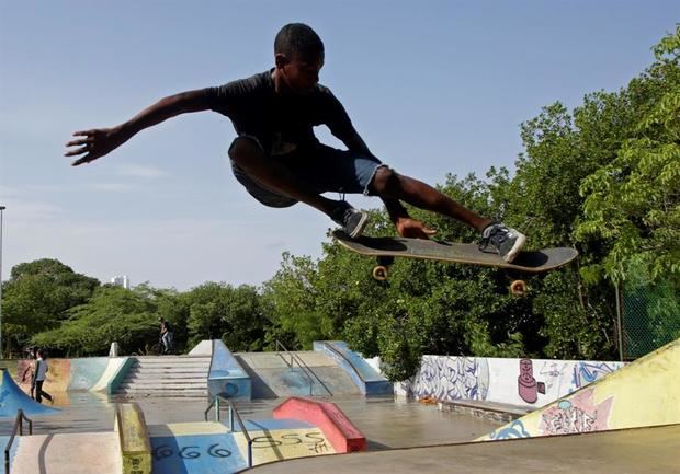 Fotografía del 2 de julio de 2020 que muestra a un joven haciendo una acrobacia sobre una patineta en Cartagena (Colombia).