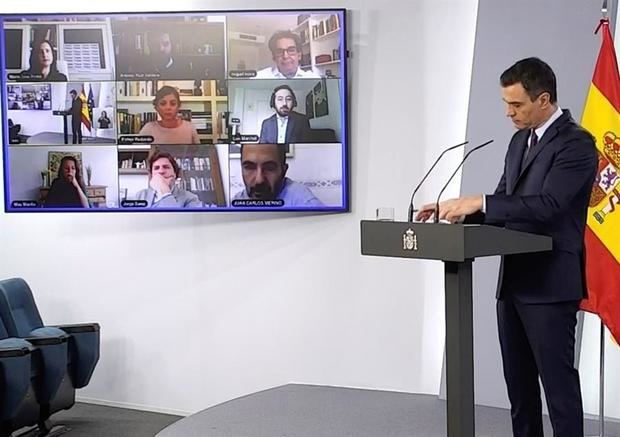 Captura tomada de la señal institucional del Palacio de la Moncloa del presidente del Gobierno, Pedro Sánchez (dcha), escucha las preguntas hechas por varios periodistas de forma telemática durante la rueda de prensa que ofreció este sábado en el Palacio de la Moncloa, en Madrid.