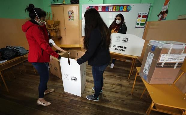 Jurados electorales instalan un puesto de votación hoy en un centro electoral en Quito, Ecuador.