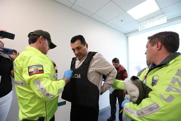 Fotografía cedida este viernes por la Secretaría de Comunicación de Ecuador en la que se registró el momento en el que las autoridades le colocan los elementos de seguridad al exjefe de Inteligencia del expresidente Rafael Correa, Pablo Romero Quezada (c), a su arribo a Quito y antes de ser trasladado ante la justicia ecuatoriana.