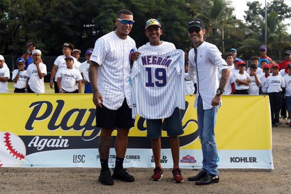 Marc Anthony (d) y el pelotero de los Chicago Cubs, Javier Báez (i), posan junto al pelotero de Little Leagues de Puerto Rico Owen Negrón (c), en la ceremonia de inauguración de un campo de béisbol recientemente renovado, hoy sábado en Loíza. Anthony y Báez celebraron este sábado la reconstrucción de un campo de béisbol en la localidad puertorriqueña de Loíza, que fue destruido por los huracanes Irma y María en 2017. 