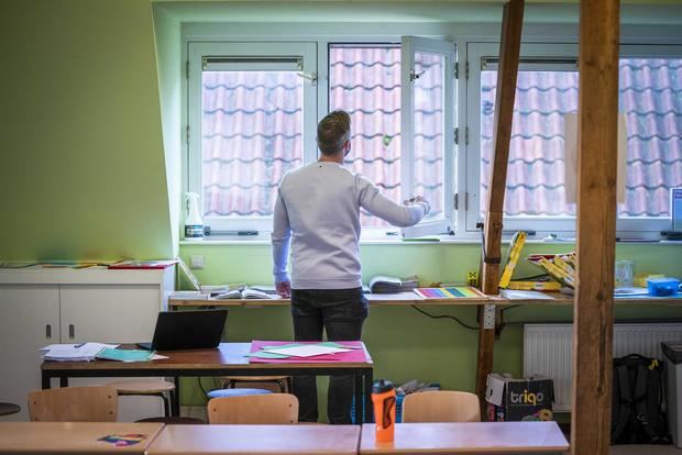 Un profesor abre las ventanas en una clase de un colegio en Bilt, Paises Bajos.