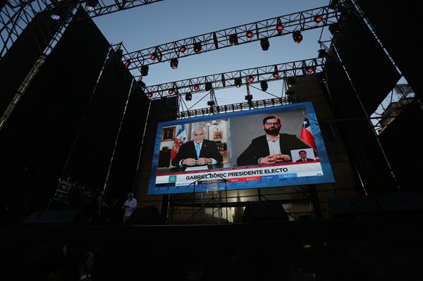 En pantallas gigantes se observa el saludo del presidente Piñera (i) al presidente electo Gabriel Boric (d), hoy en Santiago (Chile)