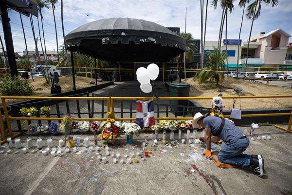 Un hombre enciende velas en la entrada de la discoteca Jet Set este viernes, en Santo Domingo (República Dominicana). 
