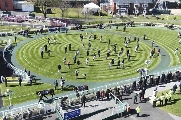 Jinetes y entrenadores guardan un minuto de silencio para honrar la memoria del príncipe Felipe, duque de Edimburgo y esposo de la reina Isabel II, en el hipódromo de Aintree, Reino Unido.