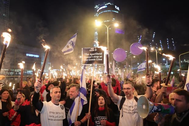 Manifestantes con antorchas participan en una multitudinaria protesta contra el Gobierno israelí de Benjamin Netanyahu en Tel Aviv.