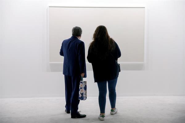 Varias personas observan las obras que se encuentran expuestas en la Galería Sabrina Amrani de Madrid en ARCOmadrid 2019. 