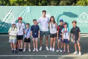 Carlos Alcaraz junto a niños participantes de la clínica de tenis.