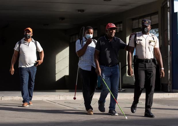 Personas caminan en la calle con la mascarilla puesta, hoy en Santo Domingo, República Dominicana.