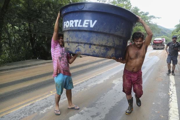 Habitantes de la zona más golpeada por las fuertes lluvias trabajan recogiendo escombros, hoy en la ciudad de Sao Sebastiao, en el litoral del estado de Sao Paulo, Brasil.