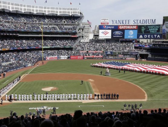 En foto de archivo del 28 de marzo del 2019, despliegan la bandera durante el Himno Nacional en el primer día de juegos de los Yanquis de Nueva York ante los Orioles de Baltimore. El 9 de abril del 2020 Forbes estimó que los Yanquis son el equipo más valioso de la MLB con 5 mil millones de dólares. 