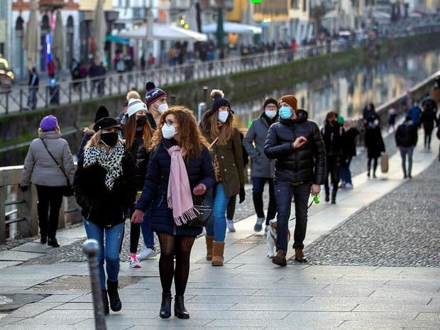 Varias personas pasean con mascarilla por Milán, Italia.