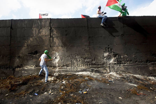 Un grupo de manifestantes con banderas palestinas intentan demoler parte del muro de separación en la parte occidental de la ciudad de Abu Dis, Jerusalén Este, Israel, en 2015.