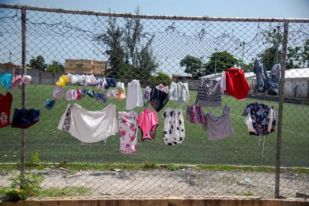 Fotografía de ropa lavada colgada para secarse en una malla en un Centro Deportivo de Carrefour, Haití.