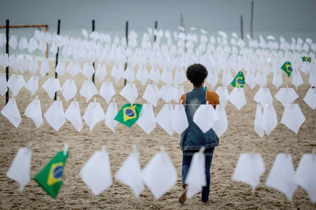 Una voluntaria ayuda a colgar pañuelos blancos durante un homenaje a las miles de víctimas mortales de la covid-19 en Brasil, hoy, en Río de Janeiro. 