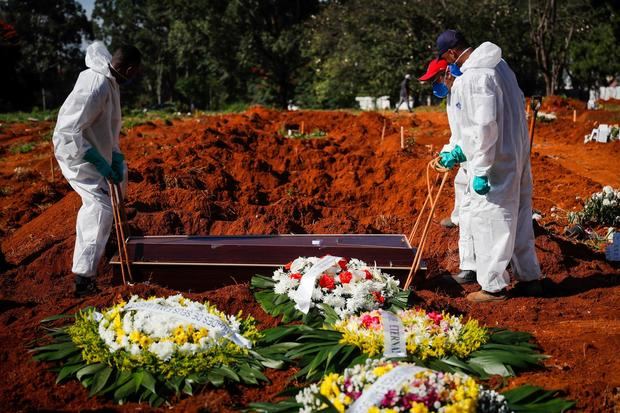 Unos trabajadores colocan un ataúd dentro de una tumba en el cementerio Vila Formosa, el 24 de marzo de 2021, en Sao Paulo, Brasil.