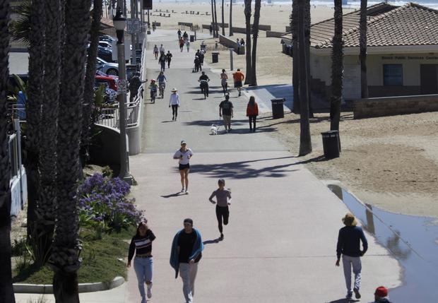 Personas sin mascarilla caminan por una calle en Huntington Beach, California (EE.UU.), en una fotografía de archivo.