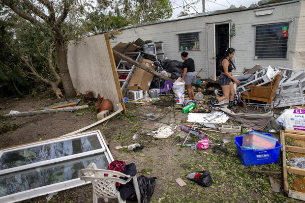Residentes en Fort Myers, Florida, buscan entre sus pertenencias tras arrasar su caravana el huracán Ian.