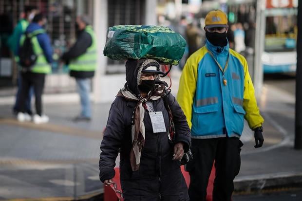 Una mujer pasa este lunes frente a controles de ingreso a la ciudad de Buenos Aires (Argentina). 