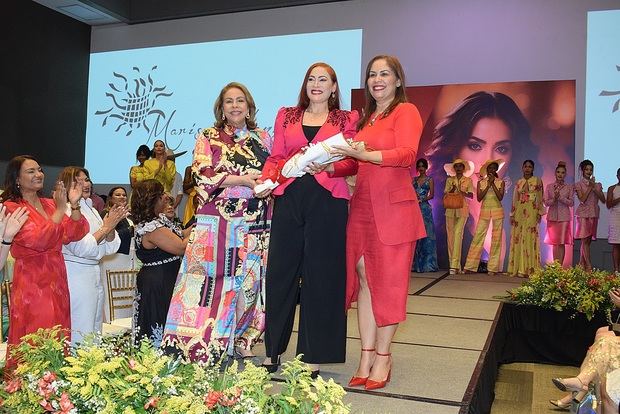 Luisa Maria de Aquino y Alexandra Tabar le otorgan un arreglo de flores a Marisol Henríquez