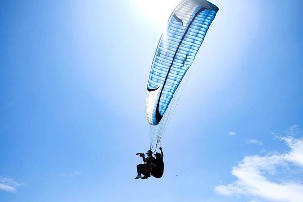 Fotografía del 30 de julio de 2021 de Jean Claude, de nacionalidad suiza y quien fundó en los años 90 de Nemaclys Parapente, junto a una turista realizan un vuelo en Puntarenas.