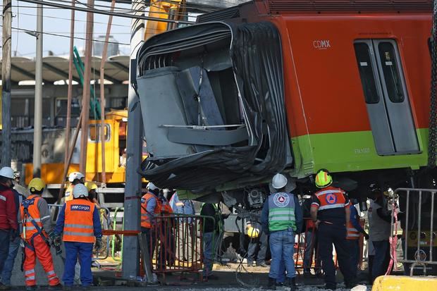 Bomberos y operarios del área de emergencias trabajan para retirar uno de los vagones del metro de la línea 12 que colapsaron en la noche del lunes, hoy en la Ciudad de México, México.