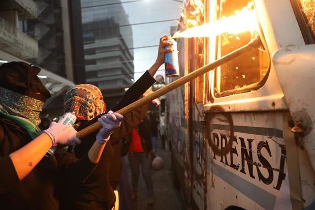 Mujeres protestan frente al periódico la prensa hoy viernes, en Ciudad de México. Cientos de activistas mexicanas que marcharon este viernes en la capital contra la violencia de género, prendieron fuego a cuatro vehículos de un periódico como un represalia a los medios que difundieron imágenes del feminicidio de Ingrid Escamilla.