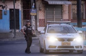 Policías vigilan tras una oleada de violencia hoy en Duran, Ecuador.