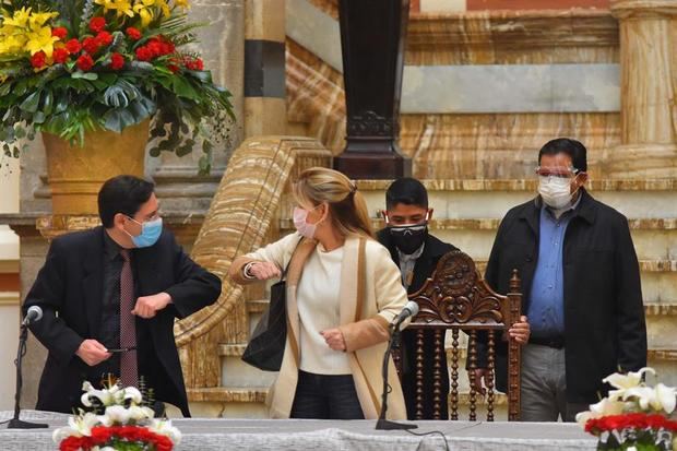 El presidente del Tribunal Supremo Electoral, Salvador Romero (i), y la presidenta interina de Bolivia, Jeanine Áñez (c), se saludan antes de iniciar una mesa de diálogo en el palacio de Gobierno hoy, en La Paz, Bolivia.