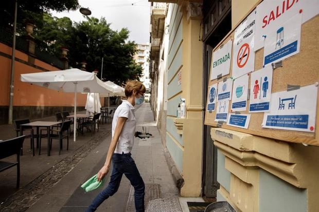 En la imagen, una camarera recoge una mesa en la terraza de una cafetería de Santa Cruz de Tenerife tras el decreto del Gobierno de Canarias que prohíbe el consumo en interiores en los negocios de restauración. 
