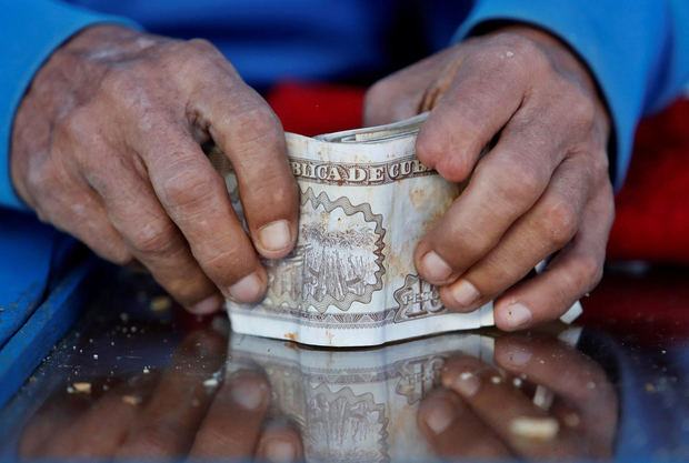 Vista de un hombre mientras organiza billetes de pesos cubanos (CUP), en La Habana (Cuba), en una fotografía de archivo.