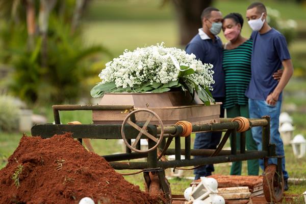 Un grupo de personas asiste al entierro de un ser querido víctima de covid-19, en el cementerio Campo da Esperança, en la ciudad de Brasilia (Brasil). 