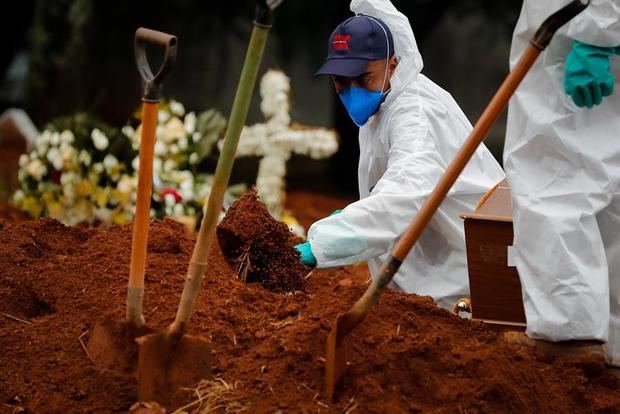 Trabajadores entierran a una víctima de covid-19 en el Cementerio Viola Formosa de Sao Paulo, Brasil.