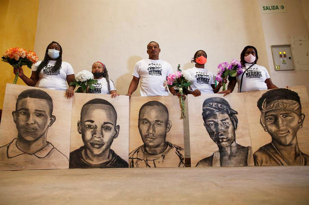 Familiares de las víctimas de la masacre de Llano Verde, sostienen hoy retratos suyos durante un acto conmemorativo, en Cali (Colombia).