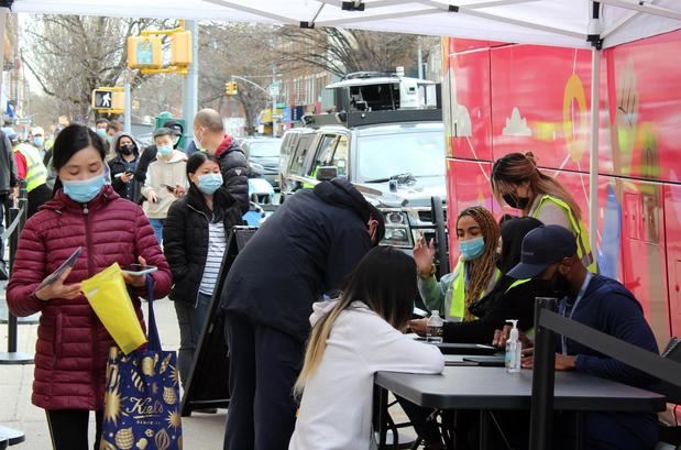 Funcionarios del Departamento de Salud de Nueva York comprueban los datos de las personas que esperan para vacunarse contra la covid-19 en los autobuses convertidos en unidad móvil para inmunización, estacionados en Sunset Park, Brooklyn, Nueva York (EE.UU).