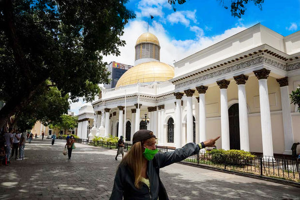 Vista de una mujer mientras camina frente al palacio federal legislativo de la Asamblea Nacional, en Caracas (Venezuela). 