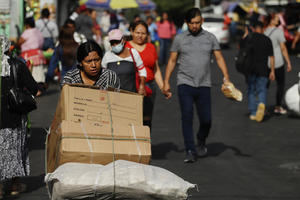 Una mujer fue registrada al trasladar su mercadería a un puesto de ventas en un mercado de San Salvador (El Salvador).