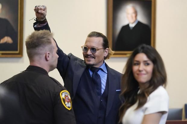 El actor estadounidense Johnny Depp hace gestos a los espectadores en el tribunal del condado de Fairfax, Virginia, EE.UU.