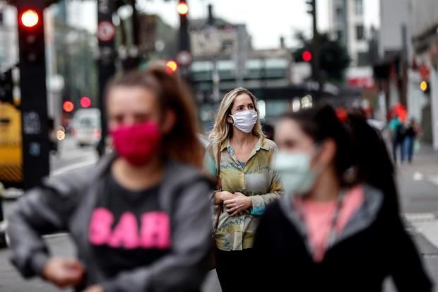 Personas con tapabocas caminan en una calle este martes en la ciudad de Sao Paulo, Brasil.