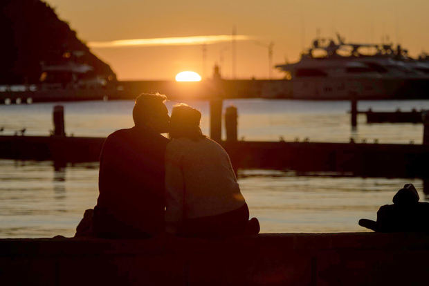 Una pareja observa la puesta de sol en el puerto de Andratx, este jueves en Mallorca, en una fotografía de archivo.