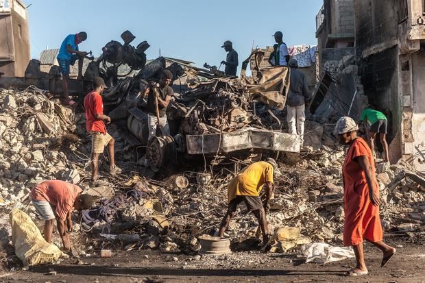 Un grupo de personas buscan hierro en una casa demolida, el 16 de diciembre de 2021, en Cap-Haitien, Haití.