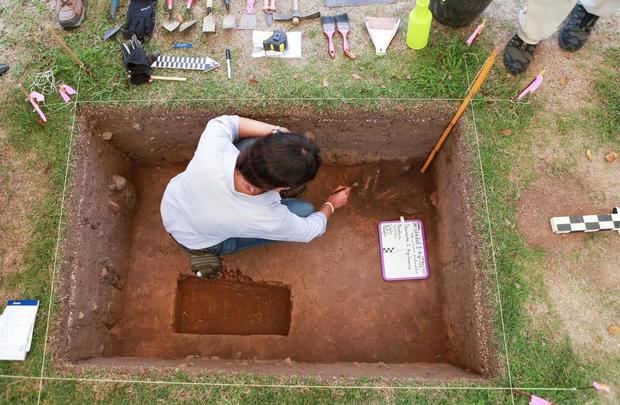 Estudiante del Centro de Estudios Avanzados de Puerto Rico y El Caribe mientras revisa la osamenta y las piezas arqueológicas encontrada en el Jardín Botánico y Cultural de Caguas, Puerto Rico.