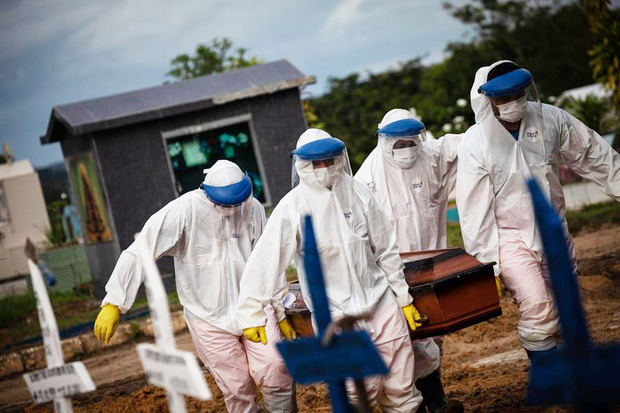 Trabajadores entierran hoy a una persona fallecida por covid-19, en el cementerio público Nossa Senhora Aparecida en Manaos, Amazonas, Brasil.