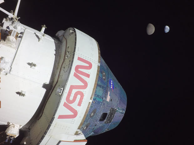 Fotografía cedida por la NASA que muestra a la cápsula Orión de la misión no tripulada Artemis I al momento de alcanzar una distancia de 432.210 kilómetros (268.563 millas) y al fondo la luna y la tierra.