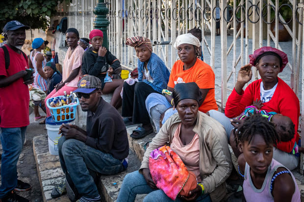 Personas piden dinero afuera de una iglesia durante la tarde de fin de año, en Puerto Príncipe, Haití.
