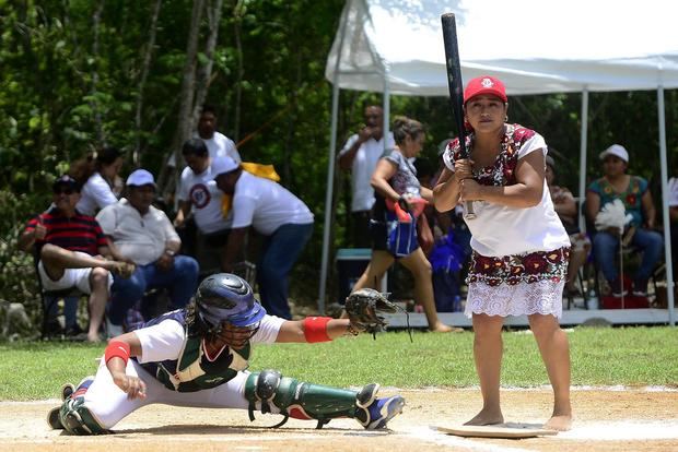 Una jugadora del equipo de Diablillas de Hodzonot (d) participa hoy, en un juego de sóftbol en la ciudad de Tulum, estado de Quintana Roo, México