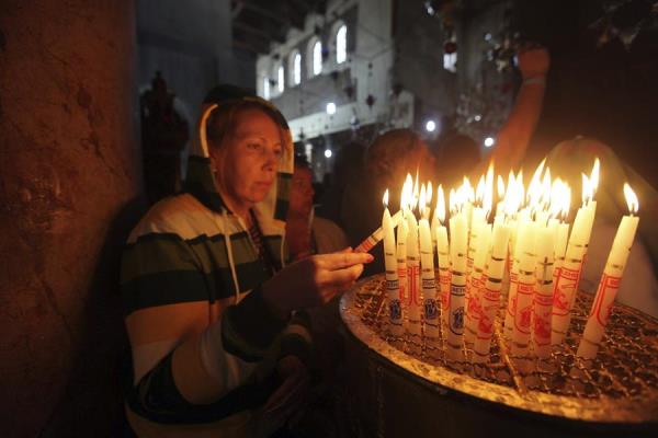 Una mujer enciende velas en la iglesia de la Natividad de Belén, donde la tradición cristiana afirma que nació Jesús de Nazaret, en la ciudad cisjordana de Belén. 